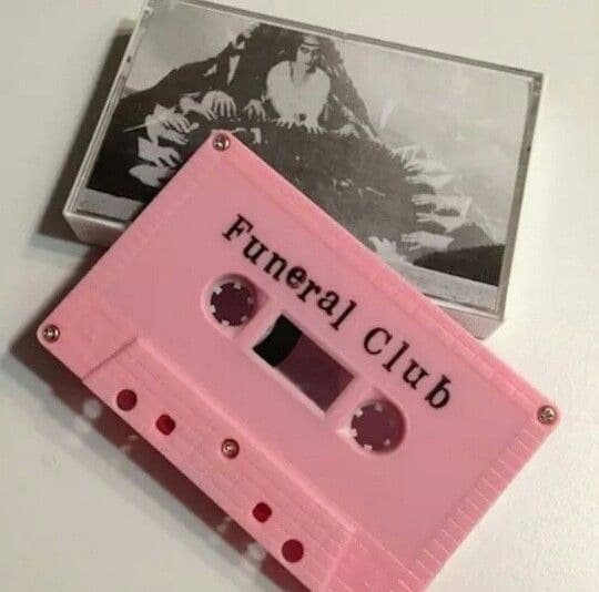 Rosafarbene Musikkassette mit der Aufschrift „Funeral Club“ vor ihrer Hülle